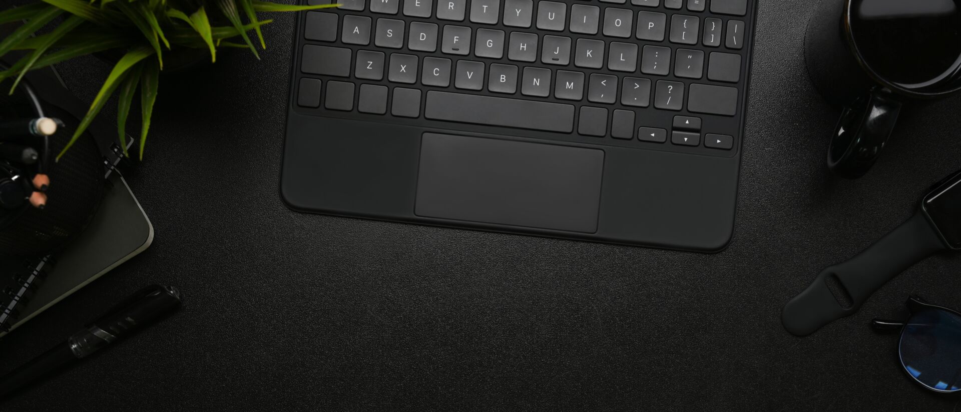 Schwarzes Bild mit schwarzer Tastatur als Arbeitsplatz für unsere SEO Experten